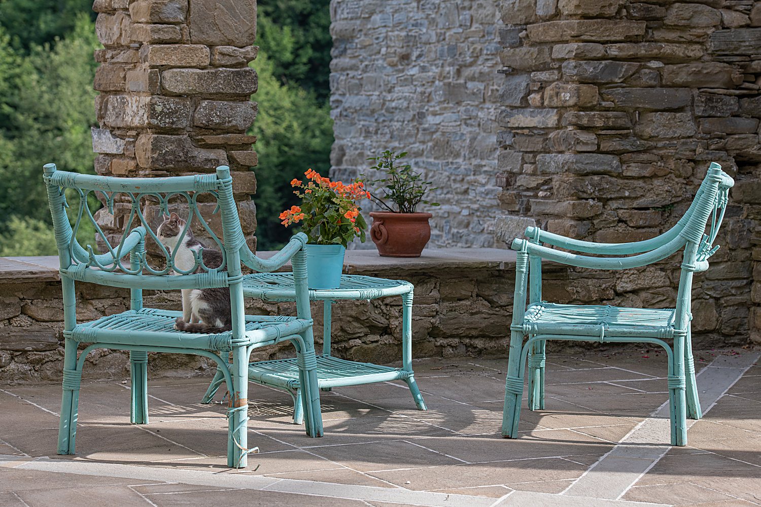 Handcrafted wooden chairs resting in a stone-walled space at Acquaviva, in soft natural light.
